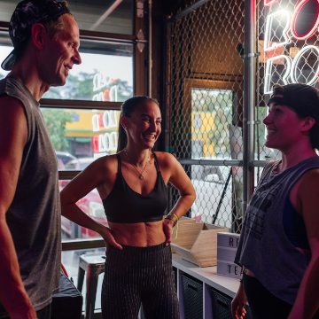 photo of one man and three women in workout gear smiling