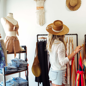 photo of woman with sunhat shopping in clothing store