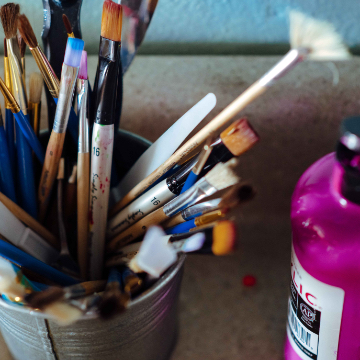 close up photo of used paintbrushes and paints
