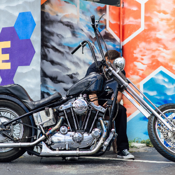 photo of chopper motorcycle in front of colorful wall