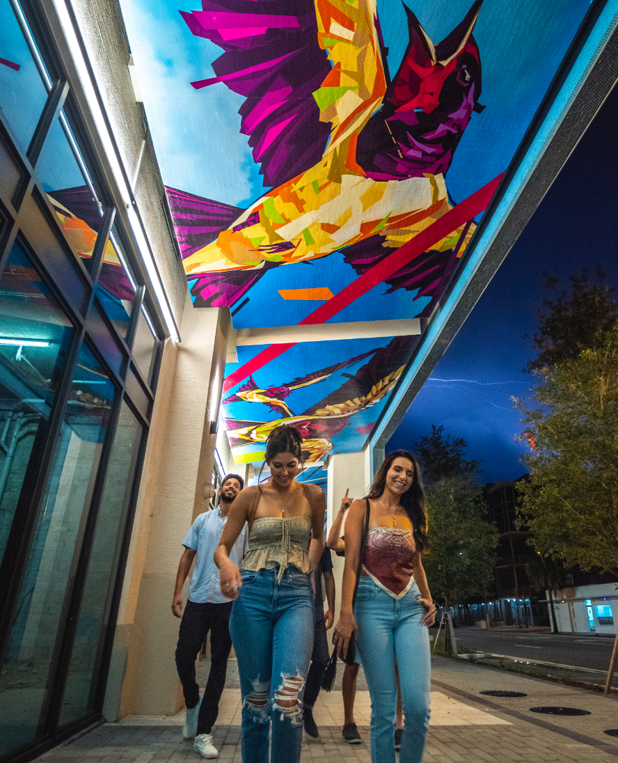 People walking under artwork in the paseo